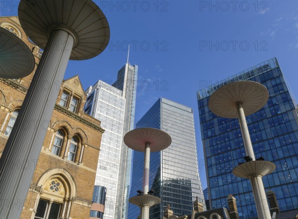 Looking up at office blocks in blue sky from forecourt of Liverpool Street station, London,