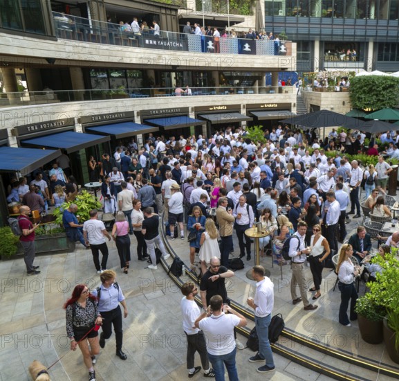 Crowd of people after work drinks outside The Botanist restaurant bar, Broadgate Circus, City of