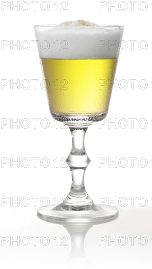 Cocktail with head of foam in a pointed goblet style glass in front of a white background, studio