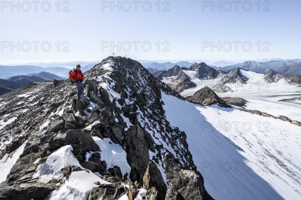 Mountaineer on narrow rocky ridge at the summit of Wilder Freiger, picturesque high mountain