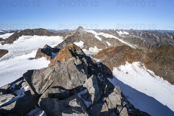 Narrow rocky ridge on the Wilder Freiger summit, picturesque high mountain landscape with snow,