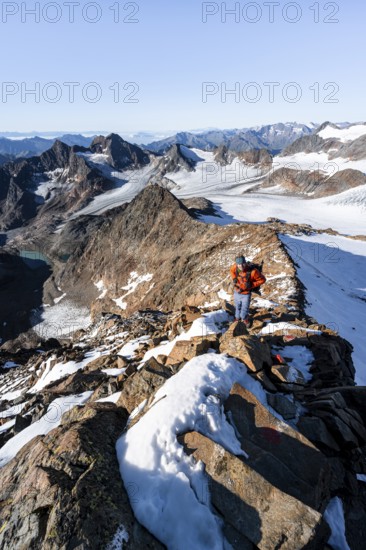 Mountaineer on a rocky ridge on the Wilder Freiger summit, behind him Signal summit and Becher
