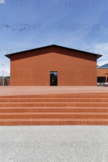Windowless building made of red bricks in the form of a warehouse, modern architecture, architect