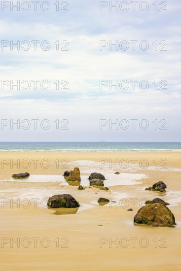 Rocks on a empty sand beach with a sea view towards the horizon in the summer, Crozon Peninsula,