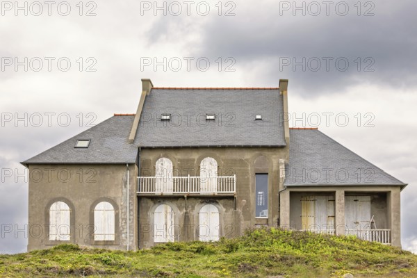 Old house with closed window shutters on a hill at a coastal area, Camaret-sur-Mer, Crozon