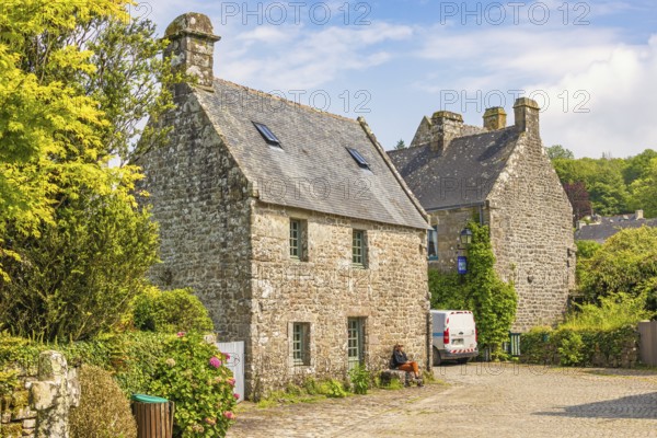 Idyllic old french village with stone houses and cobblestone streets and lush green trees a sunny