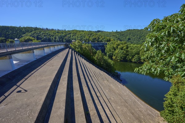 Oblique view of a dam with water reservoir surrounded by forest landscape, summer, Urft dam wall,