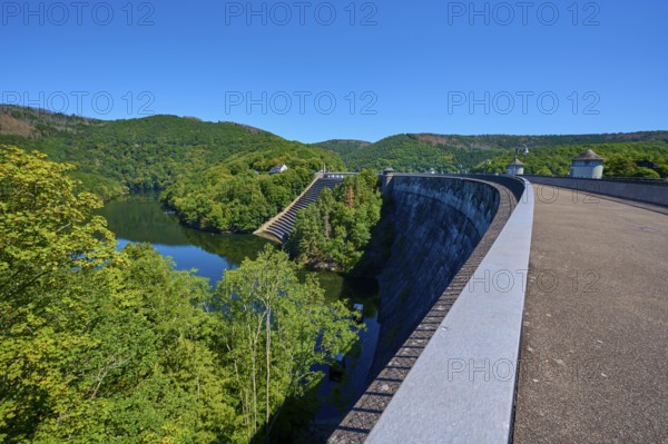 Large dam with water reservoir and lush forest under a clear sky, summer, Urft dam wall, Obersee,
