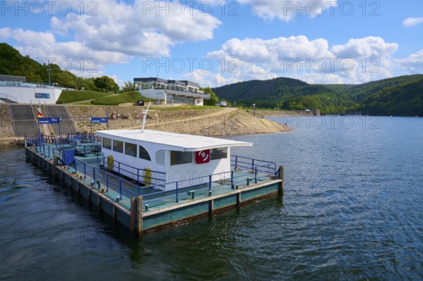 Jetty with small boat on a lake under blue sky with clouds, summer, Rursee, Obersee, Rurberg,