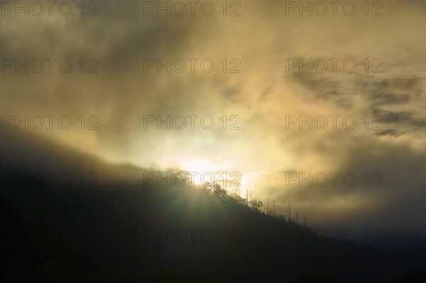 Sunrise breaks through fog over a mountain, dramatic play of light, summer, Rursee, Obersee,