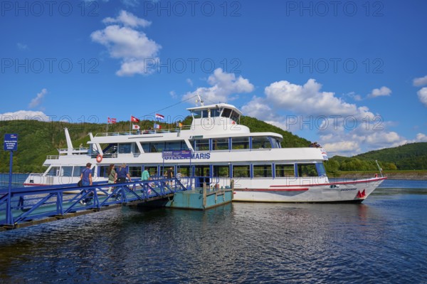 Passenger ship lying at a jetty on a lake with a deep blue sky and fleecy clouds, summer, Rursee,