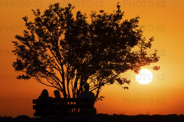 People watching the sun set on the horizon from the summit of the GroÃŸer Feldberg in the Taunus,