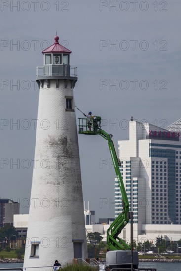 Detroit, Michigan - A worker on a lift paints the Milliken State Park Lighthouse. The lighthouse is