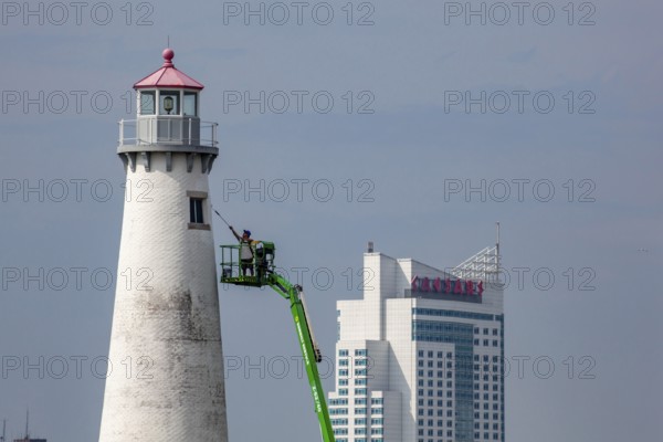 Detroit, Michigan - A worker on a lift paints the Milliken State Park Lighthouse. The lighthouse is