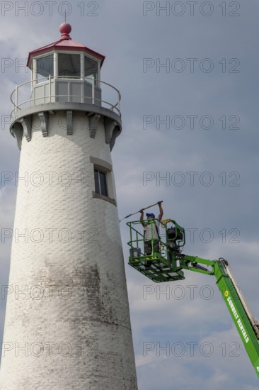 Detroit, Michigan - A worker on a lift paints the Milliken State Park Lighthouse. The lighthouse is