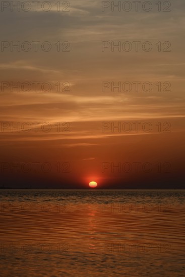 Fireball... Sunset over the Wadden Sea near Duhnen, Cuxhaven, North Sea, glowing red setting sun,