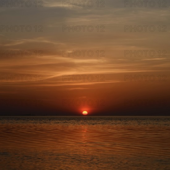 Fireball... Sunset over the Wadden Sea near Duhnen, Cuxhaven, North Sea, glowing red setting sun,