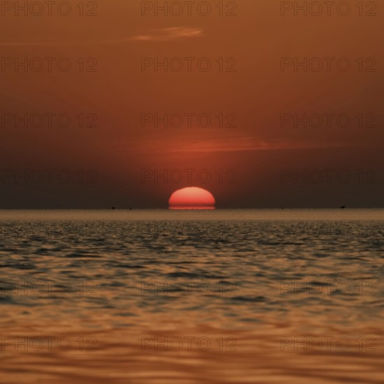When the red sun sinks into the sea... Cuxhaven, North Sea, sunset in calm weather, glowing red