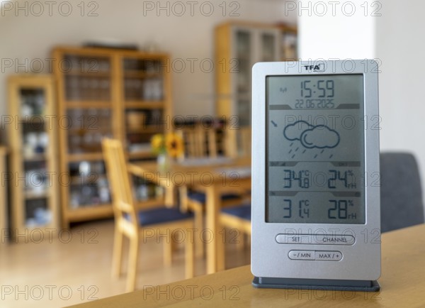 Summer heat, digital thermometer in an attic flat, city centre, outside temperature in the