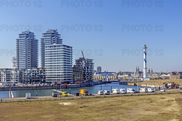 Motorhomes parked in front of lighthouse Lange Nelle and skyline of the Oosteroever quarter in