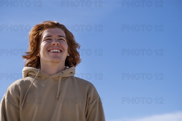 Young man red-haired, laughing, against blue sky, Jeffreys Bay near Port Elizabeth, Garden Route,