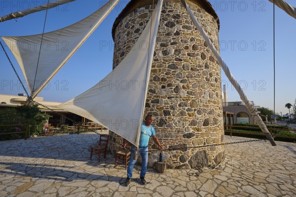 Stone windmill with a man fixing the sail, Windmill, Antimacheia, Kos, Dodecanese, Greek Islands,