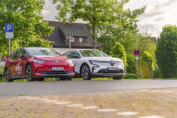 Two electric cars parked under trees in a quiet residential street, Deer E, car sharing, electric