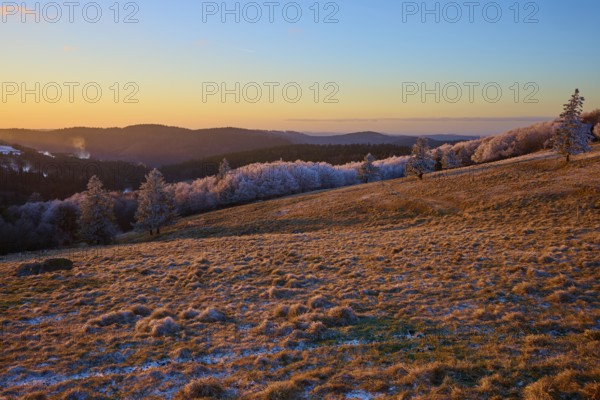 Frosty hills under a bright orange evening sky, winter, Route de Cretes, Hohneck, La Bresse,