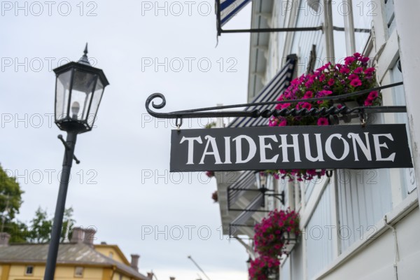 Street scene in the old town of Naantali, street view with lamp and hanging flowers in front of a