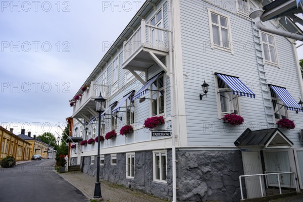 Large historic building with balconies and blooming flowers, on a quiet street in the old town,