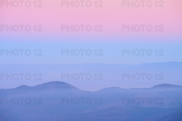 Pale hills in evening fog under a pink sky, looking towards the Rhine Valley, Hohneck, La Bresse,