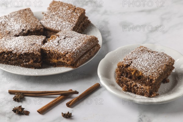 Spice cake with powdered sugar, decorated with cinnamon sticks and anise stars