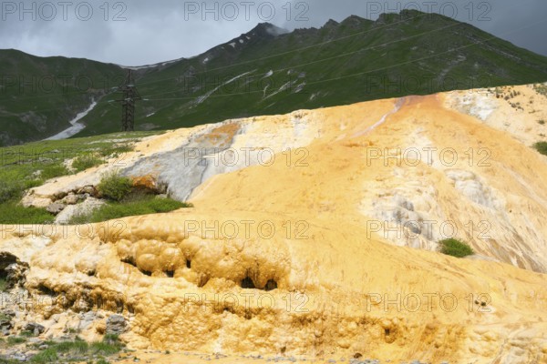 Yellow rocky landscape with green mountains and dark cloudy sky, Bidara Travertine, Travertine,