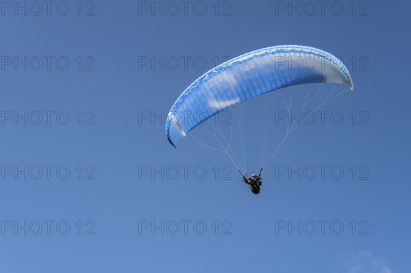 Single paraglider in the blue sky symbolizing freedom and adventure, paraglider near Gudauri,