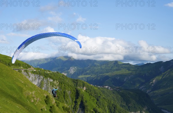 Paraglider flying with blue sky and mountain scenery, a sense of freedom and adventure, paraglider,