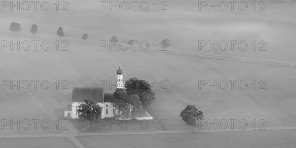 St. Coloman pilgrimage church in front of sunrise in autumn fog, Königswinkel, Ostallgäu, Allgäu,