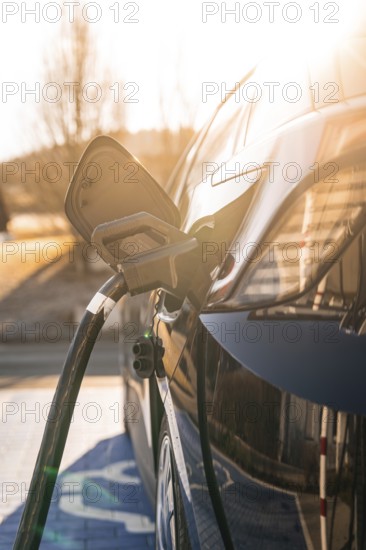 Electric car is charged in the sun, reflective surface shows environmentally friendly mobility, MG4