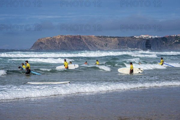 Participants in a surfing course go into the water, beach Praia de Vale Figueiras, village Arrifana