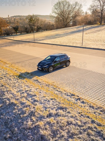 Car parked on an empty street with frosty surroundings, in early morning light, MG4 electric car,