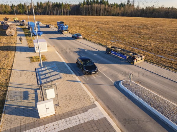 Several vehicles in a parking lot on a country road on a sunny autumn day, MG4 electric car, Deer