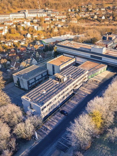 Aerial view of a large building complex surrounded by trees in an autumn landscape, MG4 electric