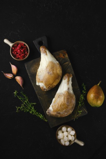 Two duck legs poached in their own rendered fat served with pear, berries, garlic and thyme on a