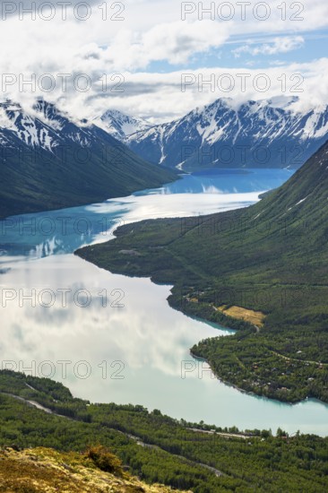 View of snowy mountains in spring and turquoise Kenai Lake with reflection, Slaughter Ridge Trail,