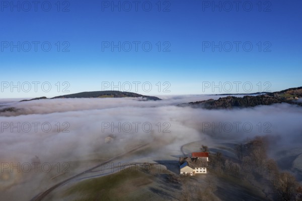 Drone view, agricultural landscape with farmhouse in autumnal morning fog, inversion weather,