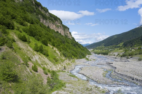 A river snakes through thick vegetation and steep cliffs, landscape near Kvemo Mleta, White Aragvi
