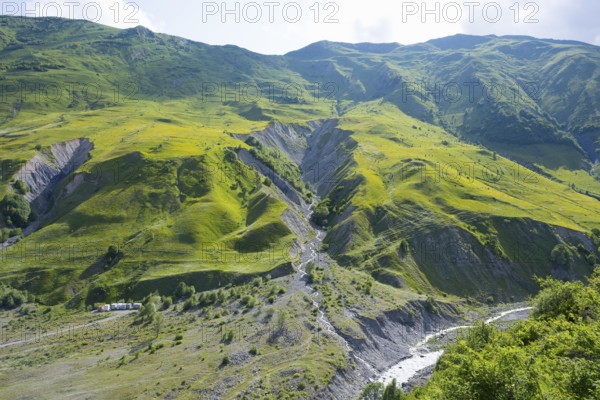 Green, steep landscape with a narrow river course in the mountains, landscape between Kvesheti and