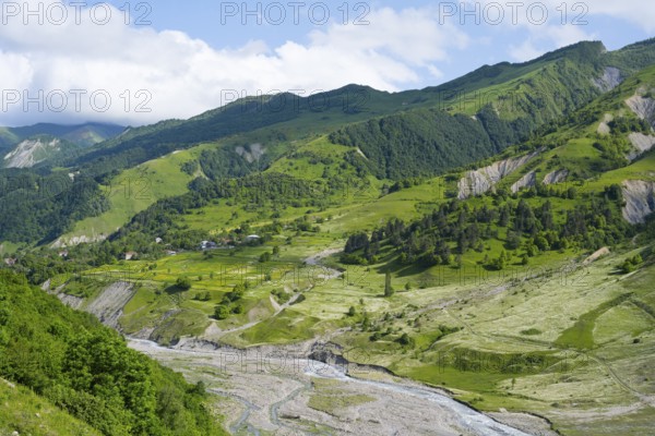 Wide green hills and a river criss-cross the mountainous landscape, landscape between Kvesheti and
