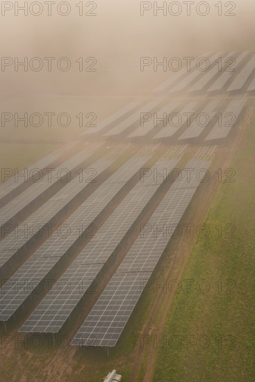 Landscape with solar panels in fog, atmospherically dense and sustainable, energy transition,