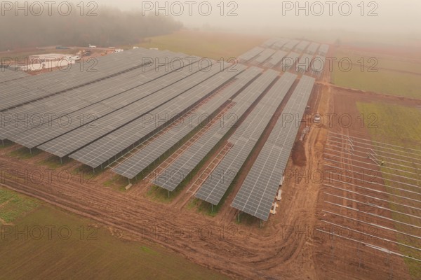 Solar fields under fog, sustainable energy in a wide field landscape, energy revolution,