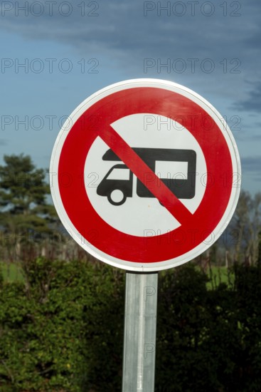 A round prohibition road sign forbids motorhomes. The sign is white with a red border and a red